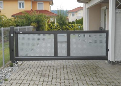 Einfahrtstor mit Muster, Farbe: schwarz und grau, Ansicht Tor mit Einfahrt, im Freien