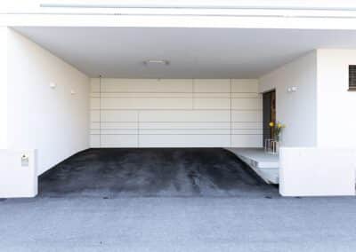 Garagentor, Farbe: weiß, Ansicht von vorne auf Haus mit geschlossenem Garagentor, Aufnahme im Freien bei Sonnenschein