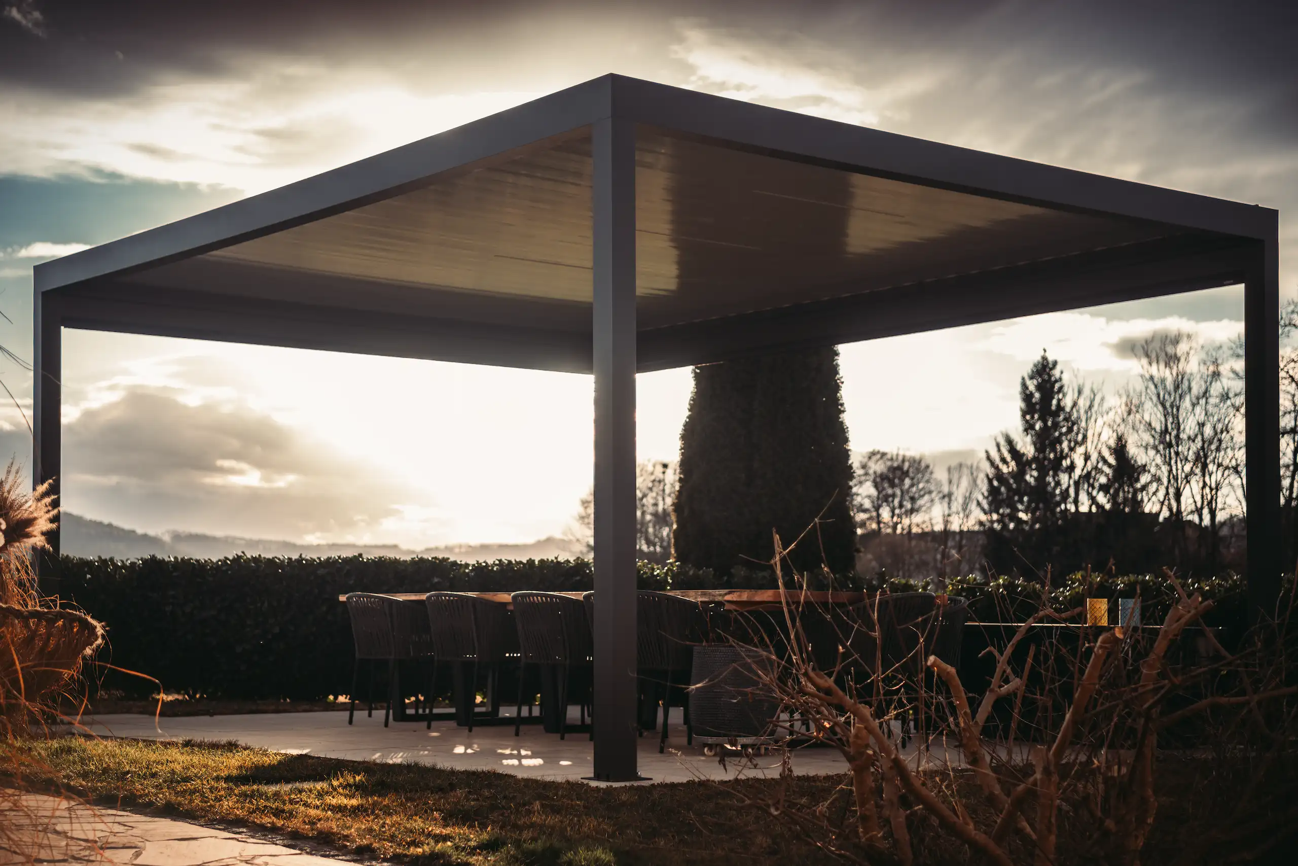 Terrasse mit grauer Pergola im sonnenuntergang